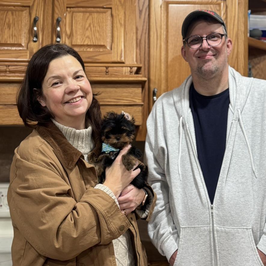 Happy family with their Yorkie puppy